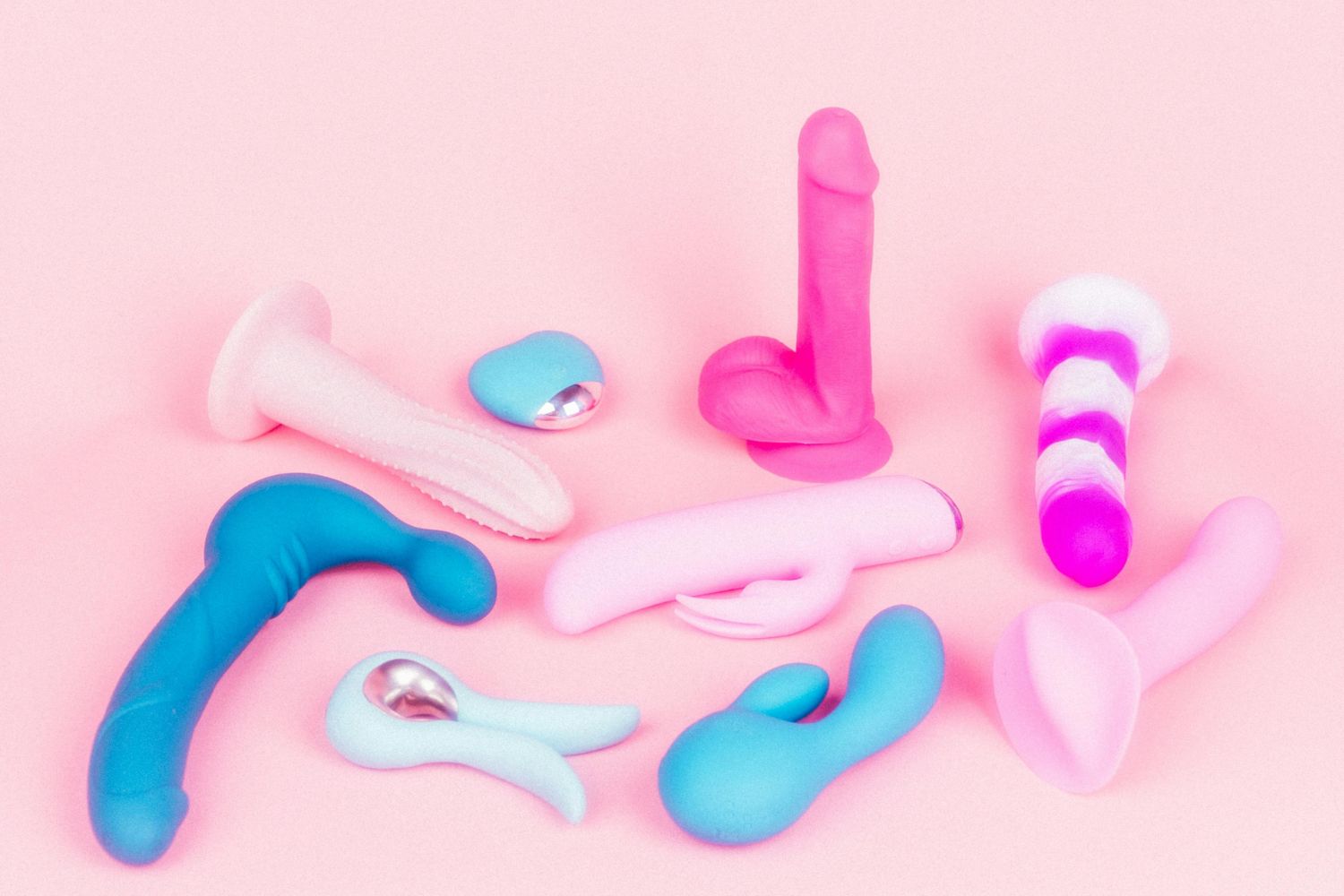 A collection of vedo sex toys on a pink background