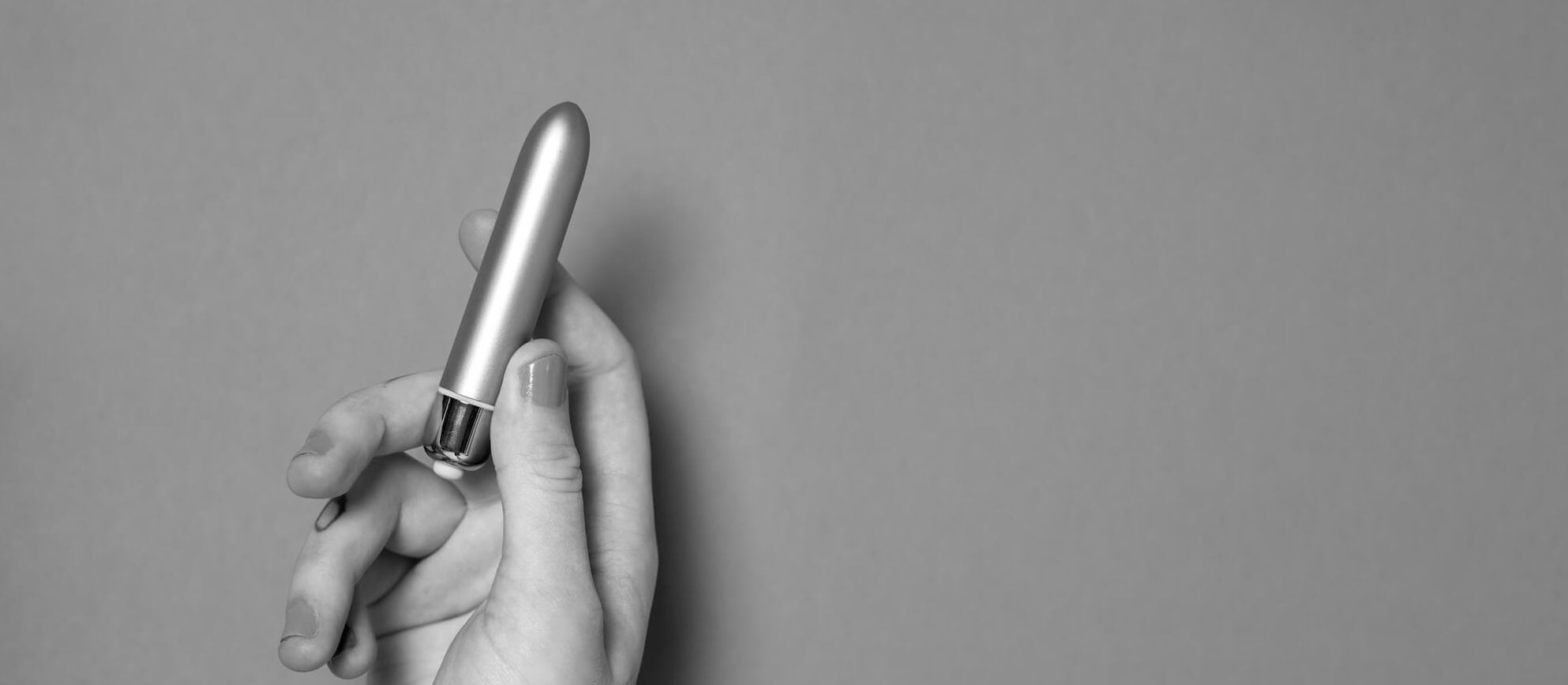 Woman holding a vibrating bullet vibrator.