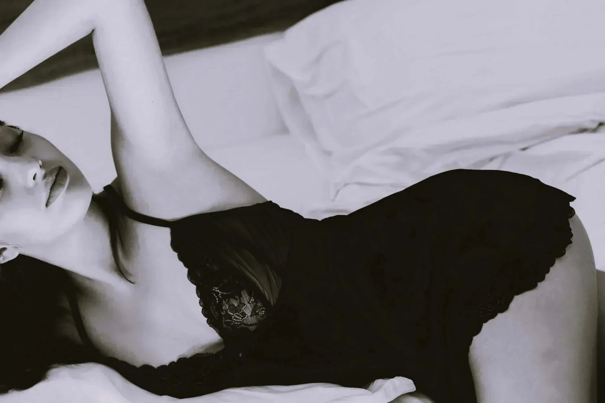 A woman lying on a bed wearing lingerie promoting realistic squirting dildo devices for women.