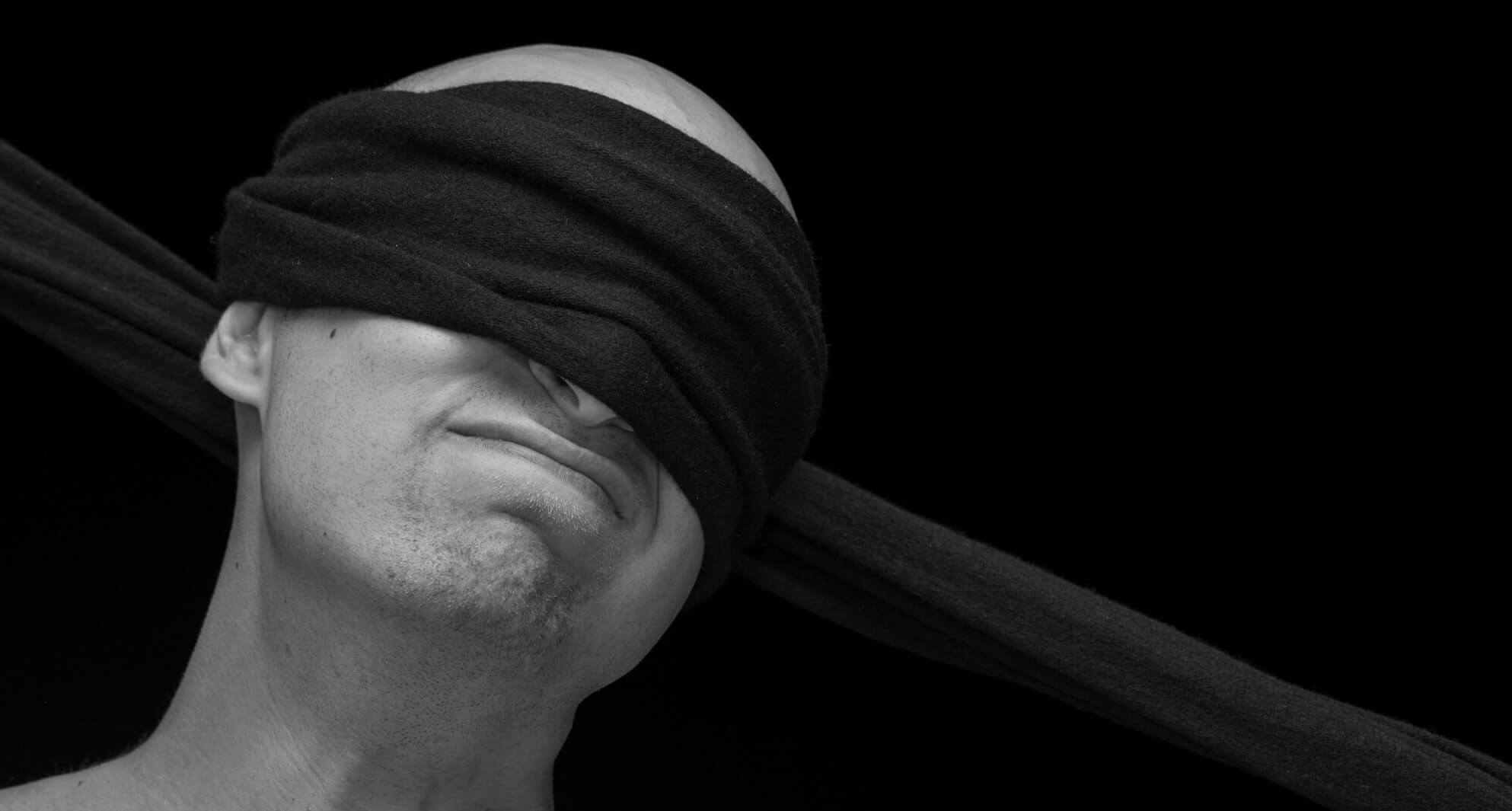 Man wearing a bondage blindfold made of soft cashmere.