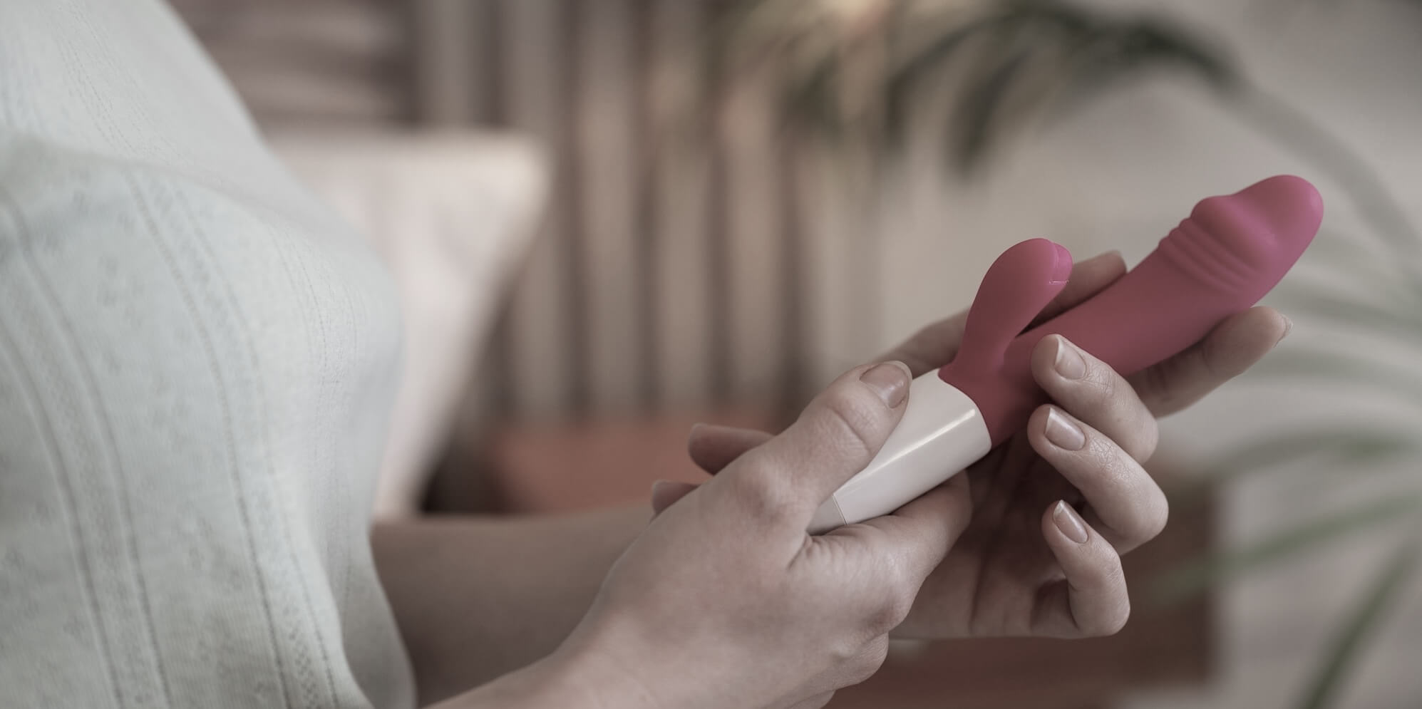 Woman holding a pink thrusting vibrator.