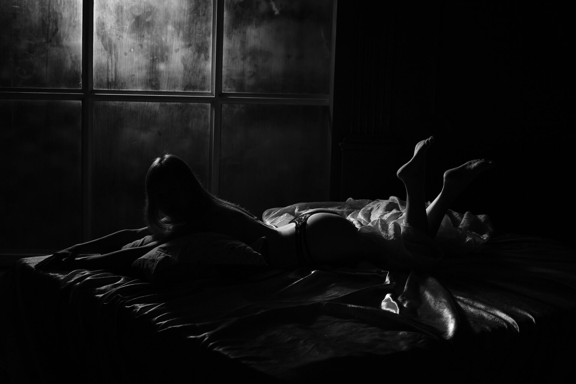 Woman on bed promoting silicone lube and silicone-based lubricants.