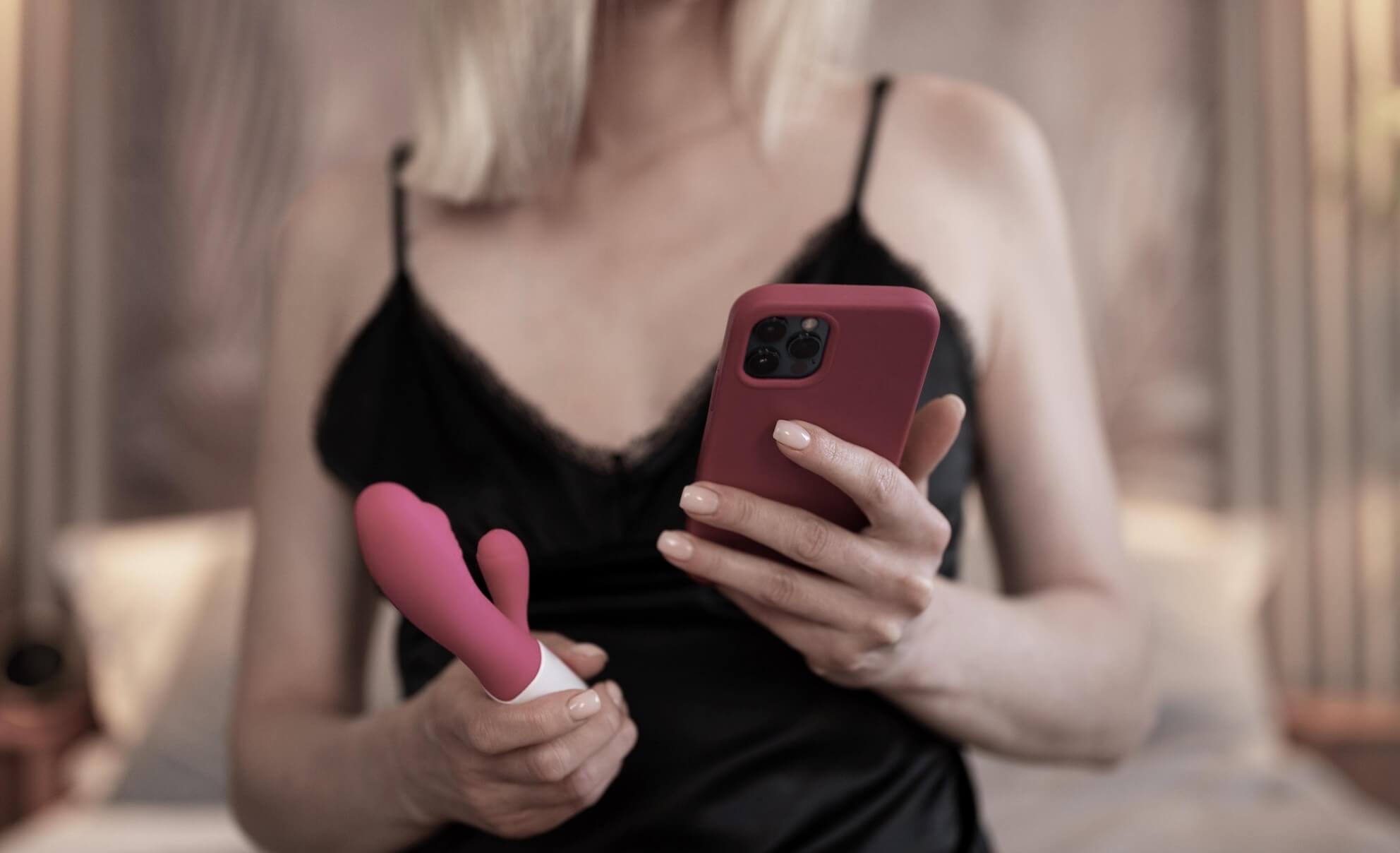 Woman holding a phone using an phone-controlled vibrators or Vibrator with Phone App.