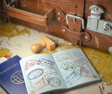 Old desk with an open passport with many stamped visas