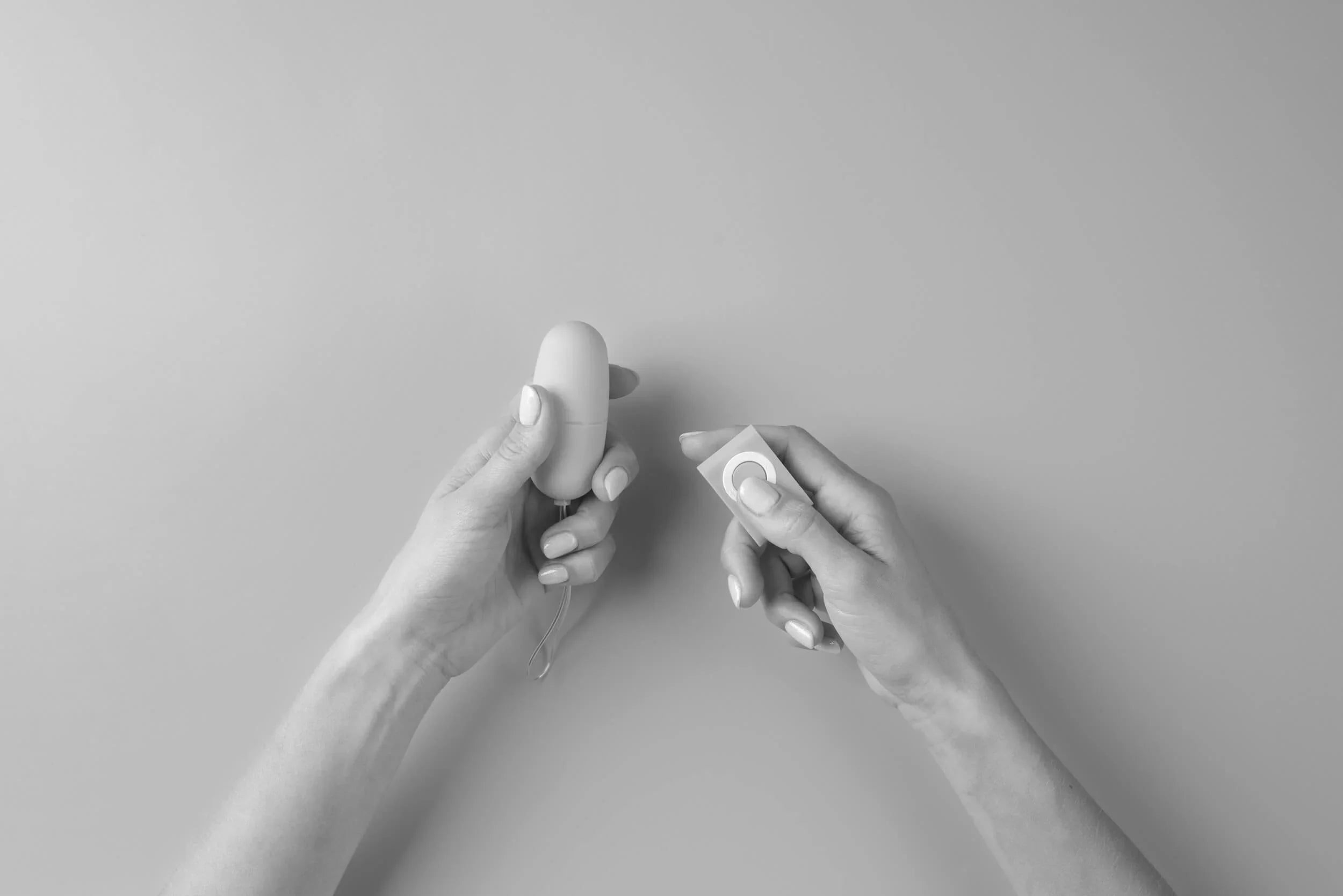 Woman hands holding an egg vibrator with a remote control