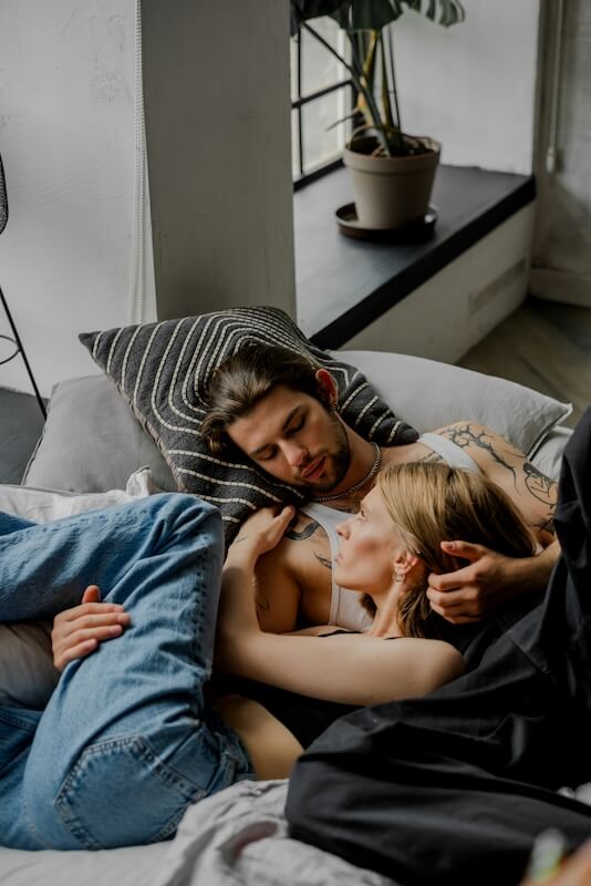 Couple cuddling together in bed